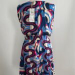 Farebné letné šaty s originálnym geometrickým vzorom okamžite pritiahnu pozornosť a dodajú sviežosť každému outfitu. Prekladaný výstrih a opasok v páse krásne formujú postavu a zvýrazňujú ženské krivky. Ľahký a vzdušný materiál zabezpečuje pohodlie počas horúcich letných dní.